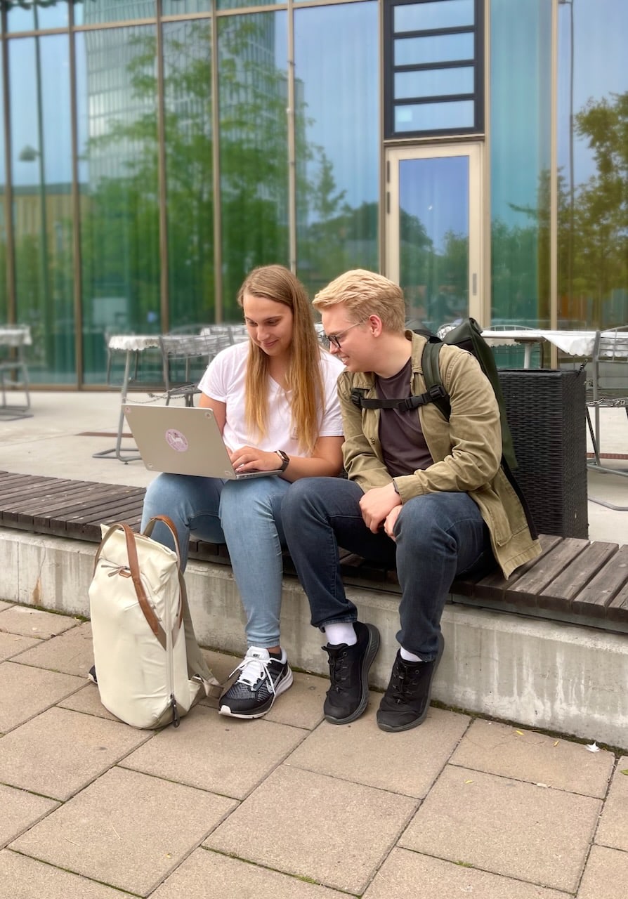 Ellie and Arvid, the founders of Merely Emissions, looking at a computer